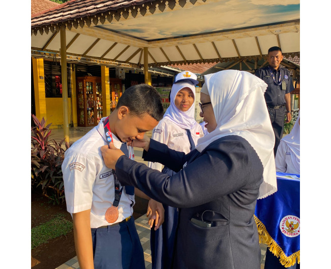 Kegiatan Kepala sekolah memberikan Mendali siswa yang berprestasi